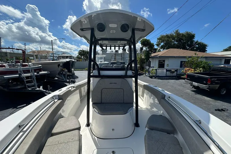Slide: The Image of 2023 Sea Pro 219 Deep V CC boat with spacious seating and T-top under a sunny sky. - 33