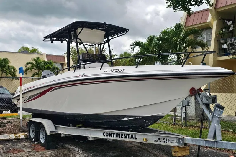The Image of 1997 Fountain Sportfish 27 boat on trailer, parked outdoors near palm trees. - 1