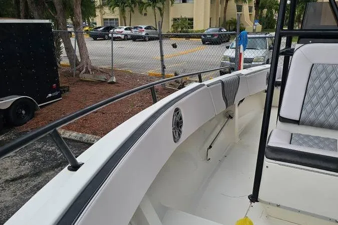 Slide: The Image of 1997 Fountain Sportfish 27 boat interior with seating and speaker, parked near a fence. - 10