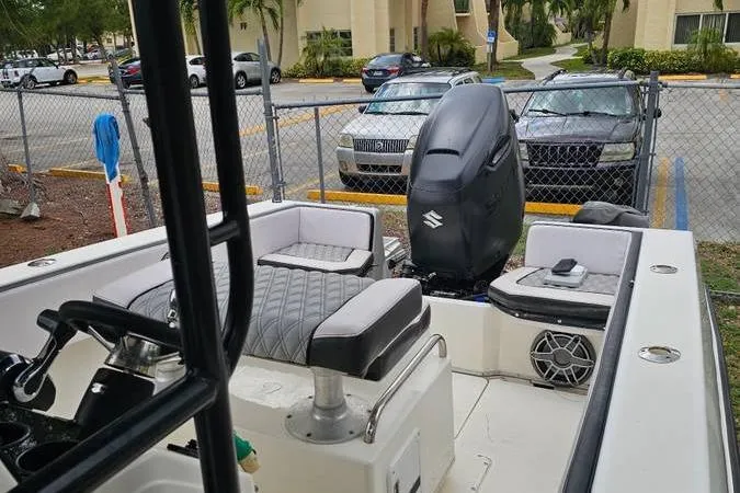 Slide: The Image of 1997 Fountain Sportfish 27 boat with Suzuki outboard motor, parked near a fence. - 13