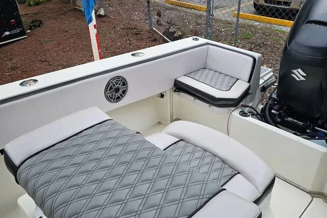 Slide: The Image of 1997 Fountain Sportfish 27 boat interior with cushioned seating and speaker. - 14