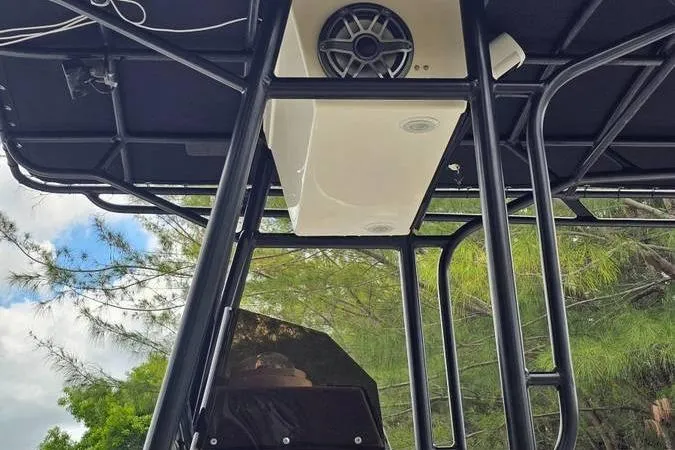 Slide: The Image of 1997 Fountain Sportfish 27 boat T-top with speaker, black frame, and outdoor setting. - 19