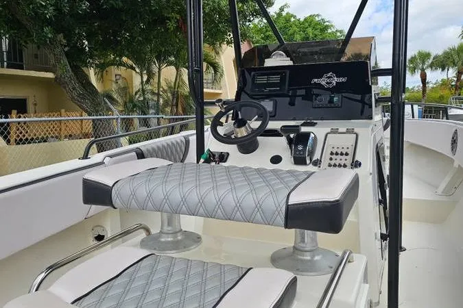 Slide: The Image of 1997 Fountain Sportfish 27 boat interior with steering wheel and cushioned seating. - 5