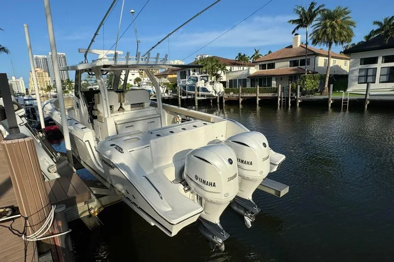 Slide: The Image of 2020 Pursuit S 328 Sport boat with twin Yamaha engines docked by waterfront homes. - 20