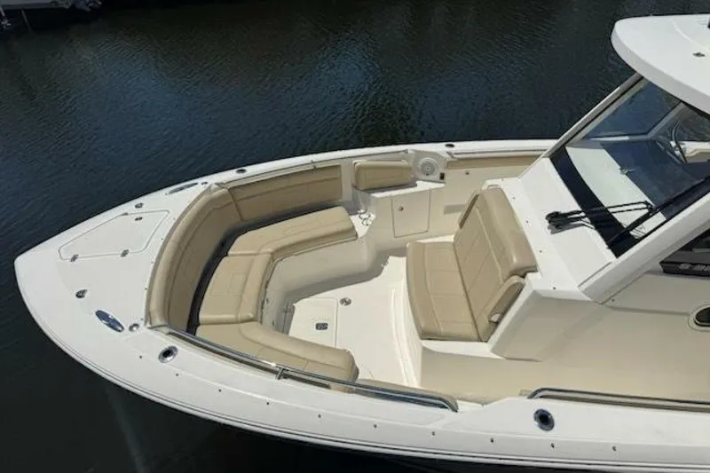 Slide: The Image of 2020 Pursuit S 328 Sport boat with beige seating, docked on calm water. - 3