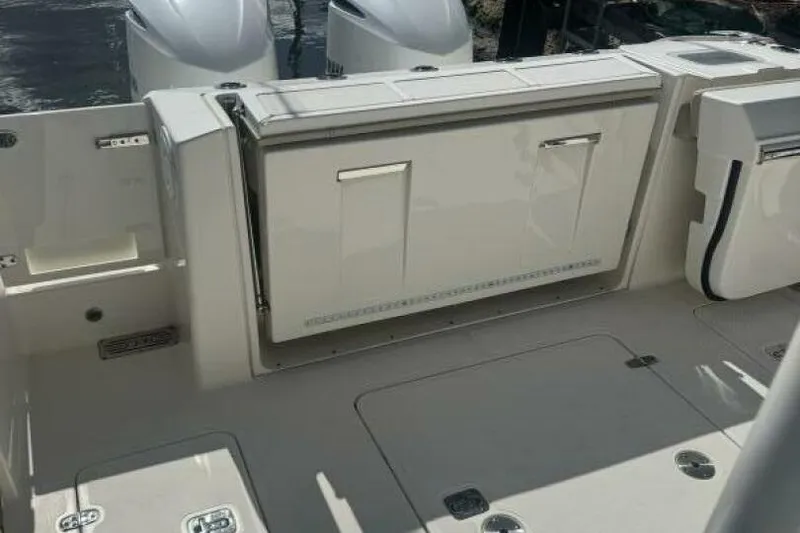 Slide: The Image of 2020 Pursuit S 328 Sport boat deck with storage compartments and dual engines. - 8