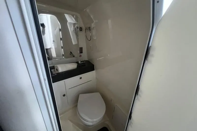Slide: The Image of 2023 Aviara 36 boat bathroom interior with toilet, sink, and storage cabinet. - 6