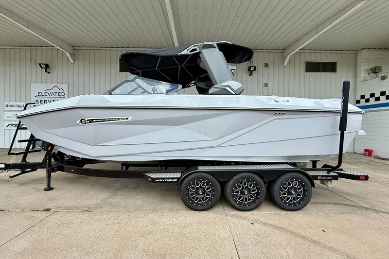 Slide: The Image of 2026 Nautique Super Air Nautique G23 boat on trailer, side view. - 0