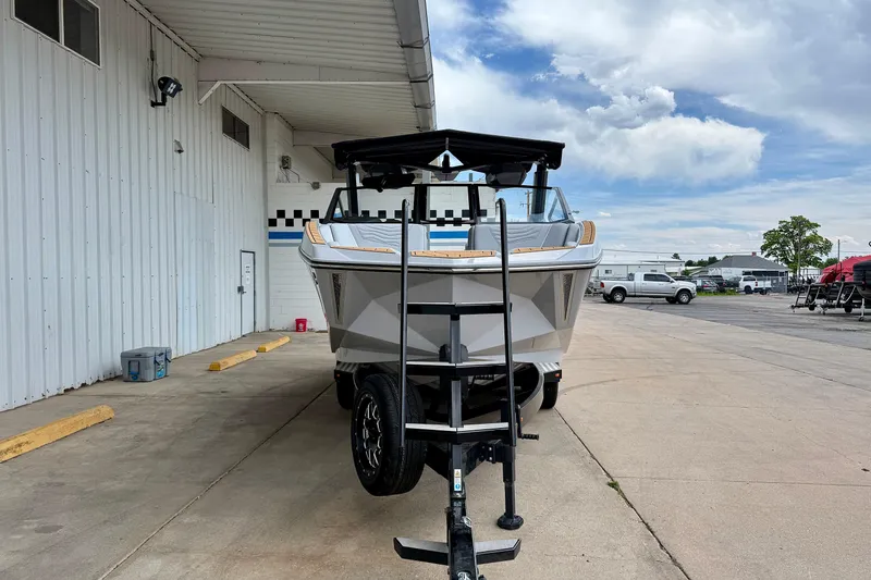 Slide: The Image of 2026 Nautique Super Air Nautique G23 boat on trailer, parked outside a building. - 1