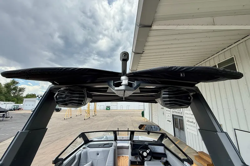 Slide: The Image of 2026 Nautique Super Air Nautique G23 boat with speakers and canopy, docked near a building. - 12