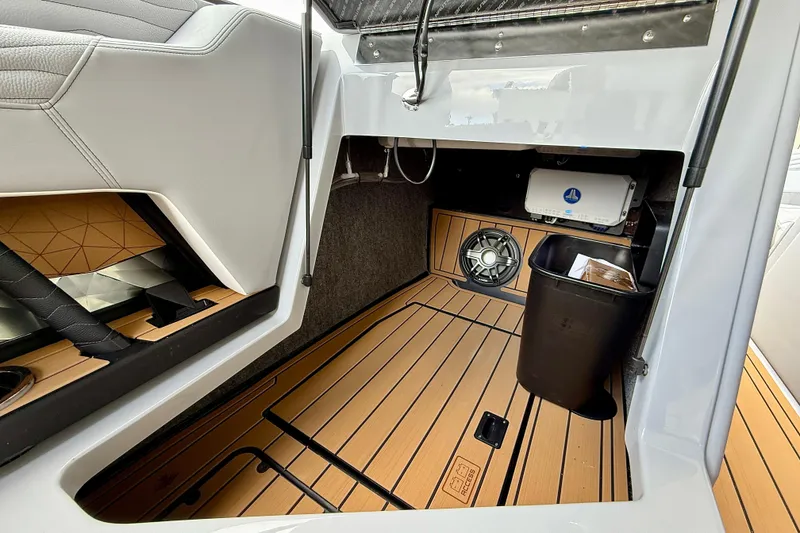 Slide: The Image of 2026 Nautique Super Air Nautique G23 interior storage with speaker and trash bin. - 17