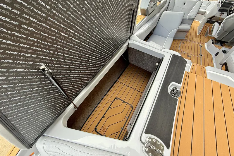 Slide: The Image of 2026 Nautique Super Air Nautique G23 interior with open storage compartment and seating. - 21
