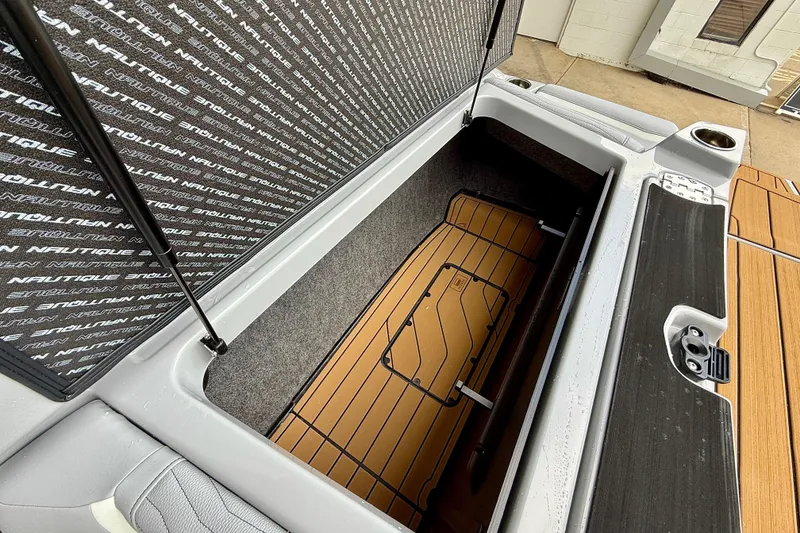 Slide: The Image of 2026 Nautique Super Air Nautique G23 storage compartment with open lid and branded interior. - 22