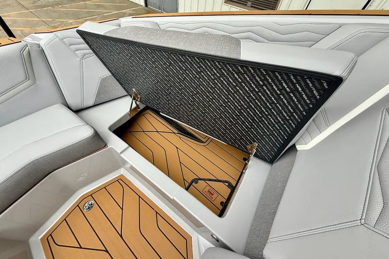 Slide: The Image of 2026 Nautique Super Air Nautique G23 interior storage compartment with stylish seating and flooring. - 26