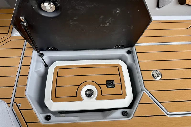 Slide: The Image of 2026 Nautique Super Air Nautique G23 storage compartment with teak-style flooring. - 37