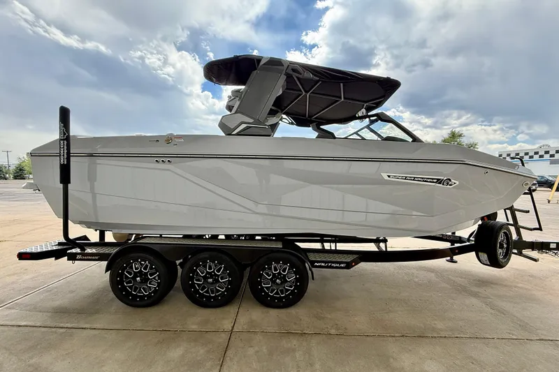Slide: The Image of 2026 Nautique Super Air Nautique G23 boat on trailer under cloudy sky. - 7