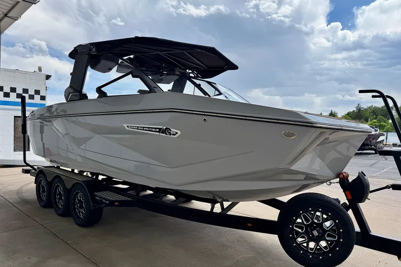 Slide: The Image of 2026 Nautique Super Air Nautique G23 boat on trailer under cloudy sky. - 8