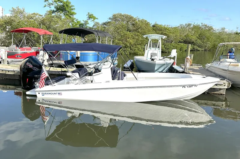 Slide: The Image of 2022 Paramount 21 boat docked, featuring a sleek design and American flag, surrounded by other boats. - 10