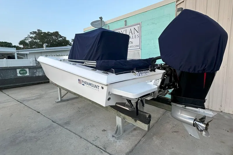 Slide: The Image of 2022 Paramount 21 powerboat with covered engine, parked on a stand outdoors. - 2