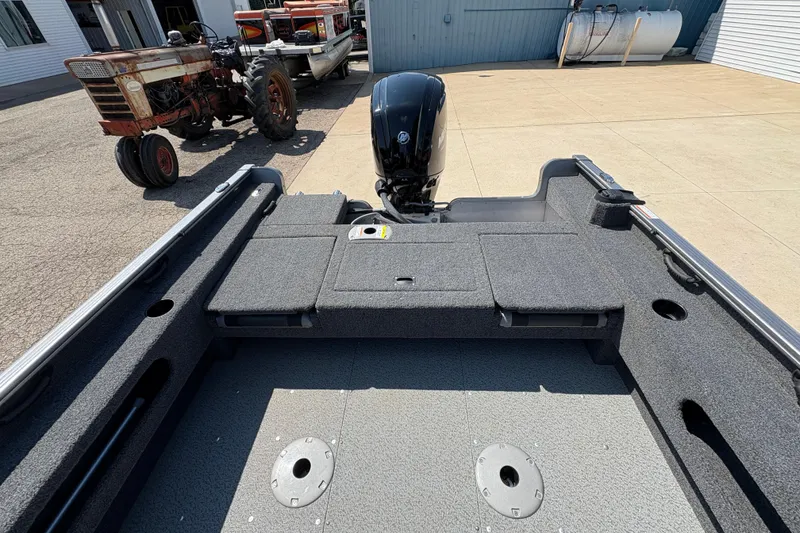 Slide: The Image of 2020 Lund 1775 Adventure SS boat interior with motor, parked near vintage tractors. - 20