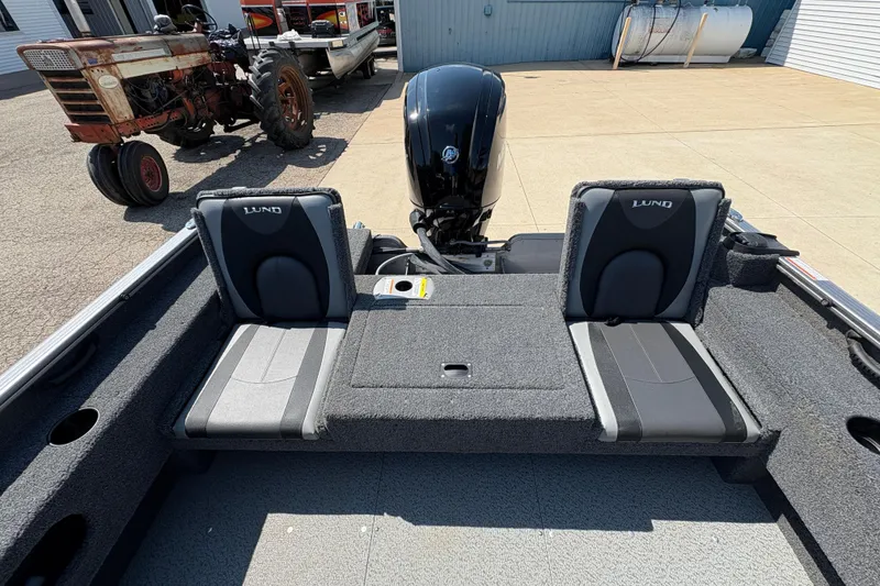 Slide: The Image of 2020 Lund 1775 Adventure SS boat interior with dual seats and motor, parked outdoors. - 22