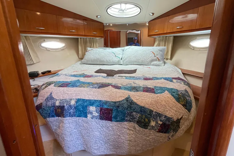 Slide: The Image of Cozy bedroom in 2003 Carver 36 Sport Sedan with quilted bedspread and wooden cabinets. - 15