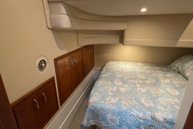 Slide: The Image of Cozy bedroom in 2003 Carver 36 Sport Sedan with nautical-themed bedding and wooden cabinets. - 19