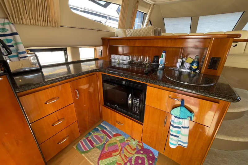 Slide: The Image of 2003 Carver 36 Sport Sedan kitchen with wood cabinetry, granite countertops, and modern appliances. - 28