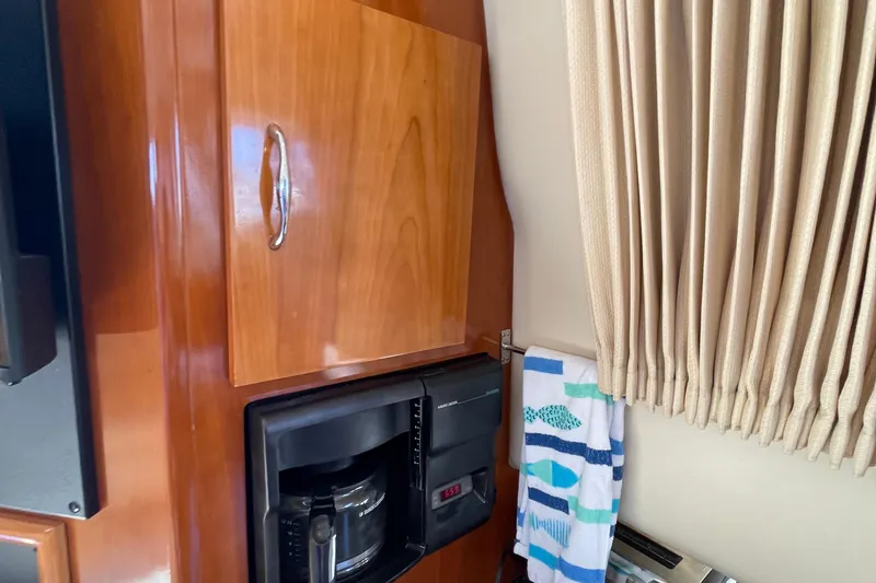 Slide: The Image of Interior of 2003 Carver 36 Sport Sedan with wooden cabinet, coffee maker, and striped towel. - 31