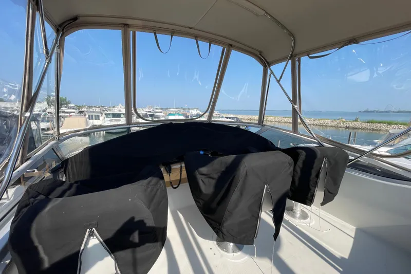 Slide: The Image of 2003 Carver 36 Sport Sedan interior with covered seats, overlooking marina and water. - 37