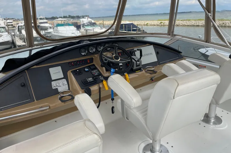 Slide: The Image of 2003 Carver 36 Sport Sedan helm with white seats, steering wheel, and navigation equipment. - 41