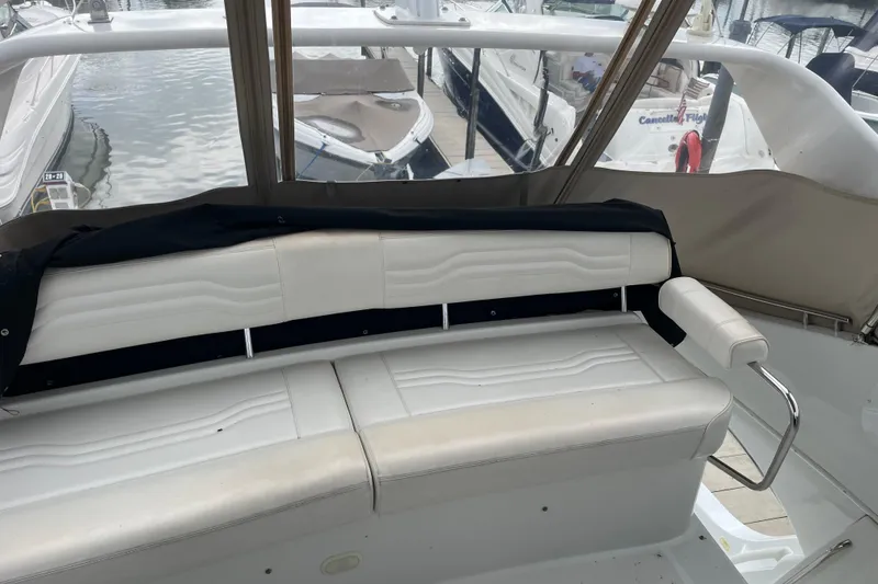 Slide: The Image of 2003 Carver 36 Sport Sedan interior with white seating and marina view. - 43