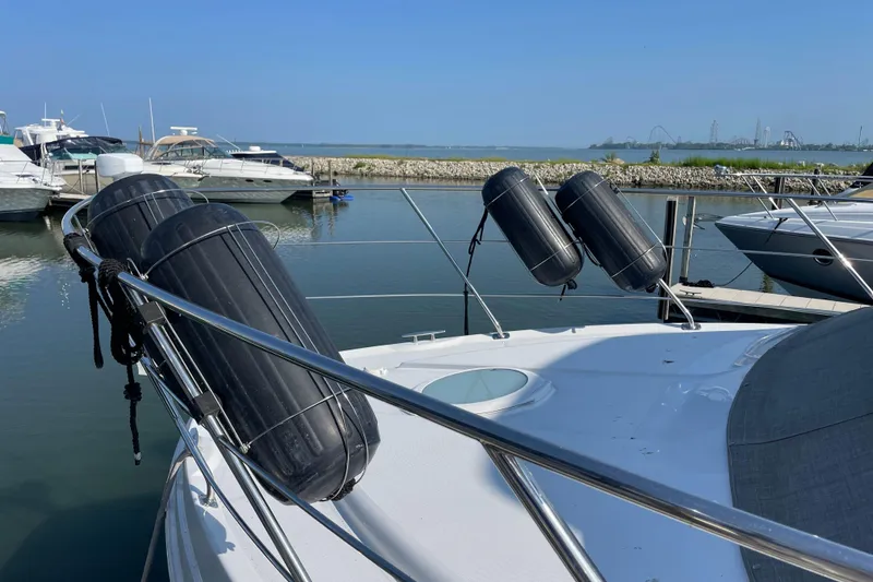 Slide: The Image of 2003 Carver 36 Sport Sedan docked with fenders, calm marina view. - 5
