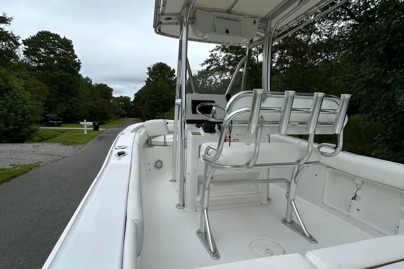 Slide: The Image of 2016 Sea Hunt Ultra 210 boat interior with seating and steering console on a road. - 14