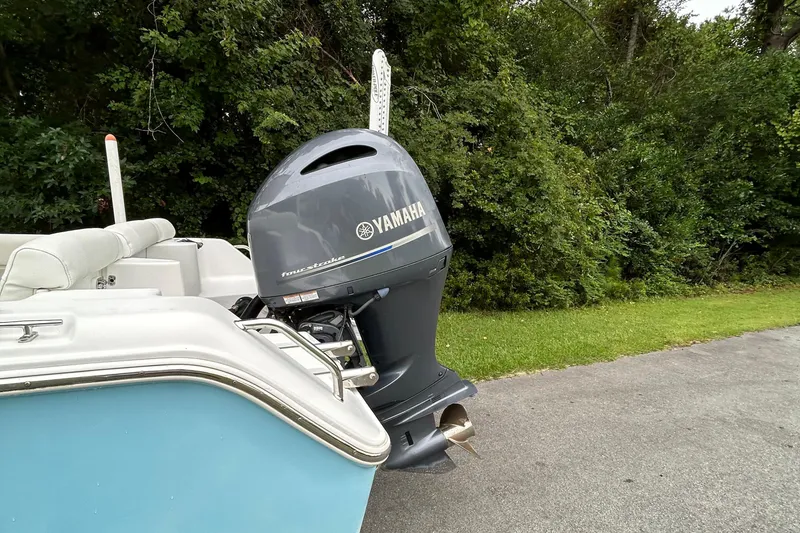 Slide: The Image of 2016 Sea Hunt Ultra 210 boat with Yamaha outboard motor, parked near lush greenery. - 20
