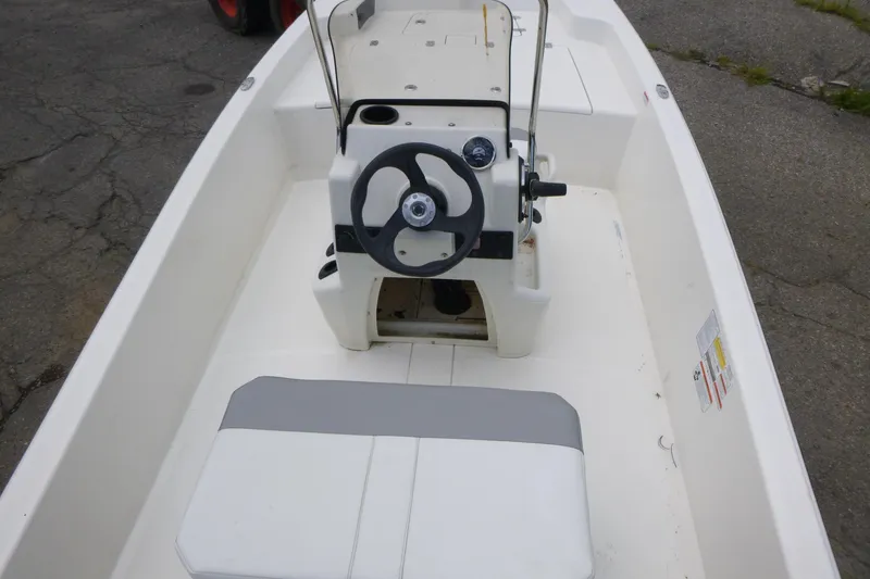 Slide: The Image of 2023 Mako Pro Skiff 15 CC boat interior with steering wheel and seating. - 5