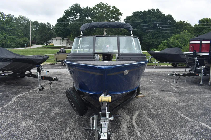 Slide: The Image of 2026 Lund 1775 Adventure Sport boat on trailer, parked outdoors. - 2
