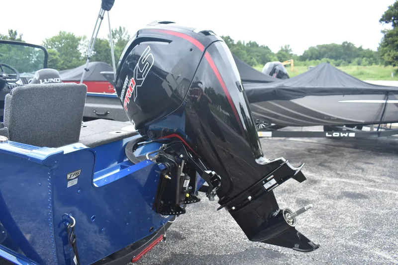 Slide: The Image of 2026 Lund 1775 Adventure Sport boat with powerful outboard motor in a parking area. - 5