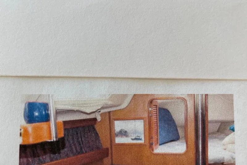 Slide: The Image of Interior of a 1998 Hunter 340 sailboat cabin with wooden finish and cozy bedding. - 10