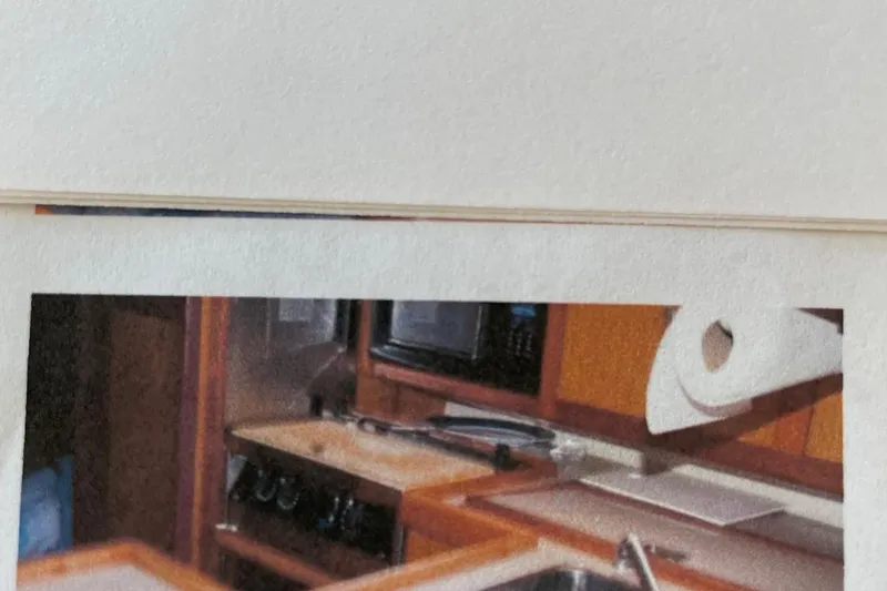 Slide: The Image of Interior of a 1998 Hunter 340 yacht kitchen with wooden cabinetry and appliances. - 12