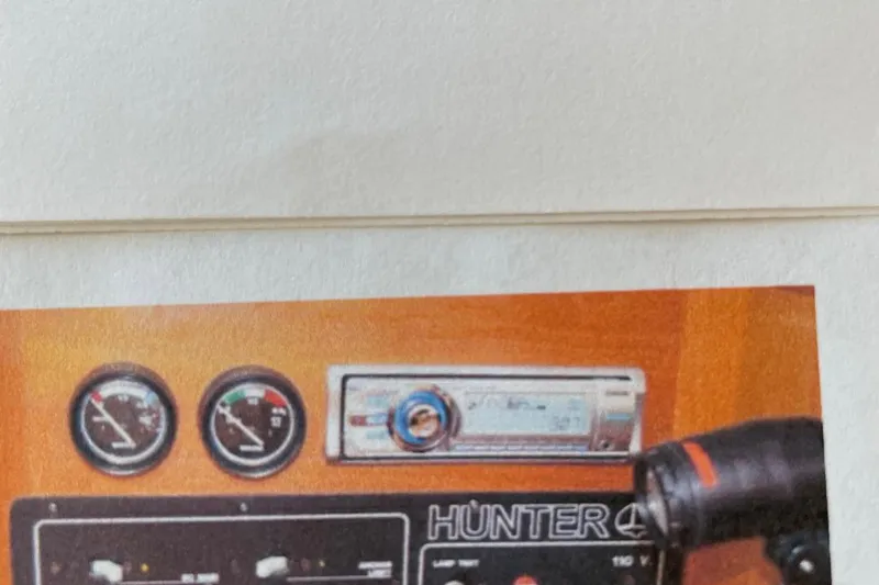 Slide: The Image of Control panel of a 1998 Hunter 340 boat with gauges and stereo system. - 13