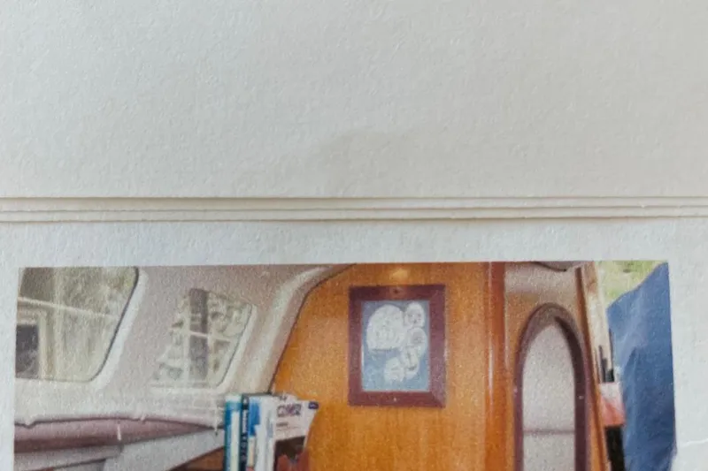 Slide: The Image of Interior of a 1998 Hunter 340 sailboat with wooden paneling and framed artwork. - 15