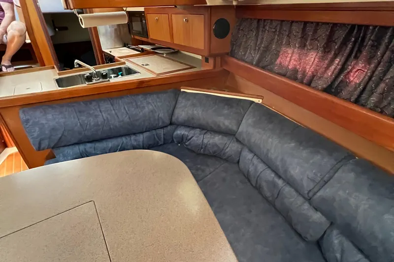 Slide: The Image of Interior of a 1998 Hunter 340 sailboat with blue seating and wooden cabinetry. - 17