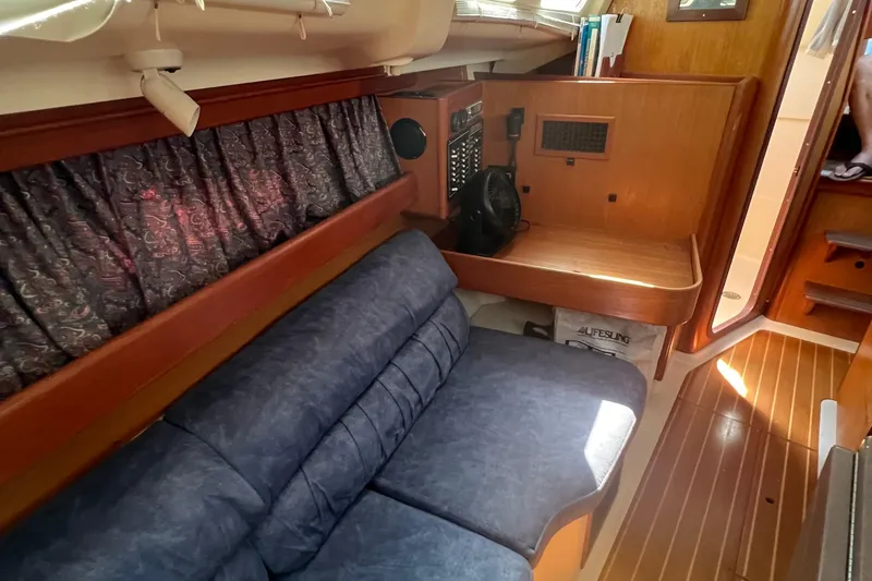 Slide: The Image of Interior of a 1998 Hunter 340 sailboat with blue seating and wooden accents. - 18