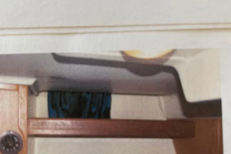 Slide: The Image of Interior view of a 1998 Hunter 340 sailboat, featuring wood paneling and a window. - 21