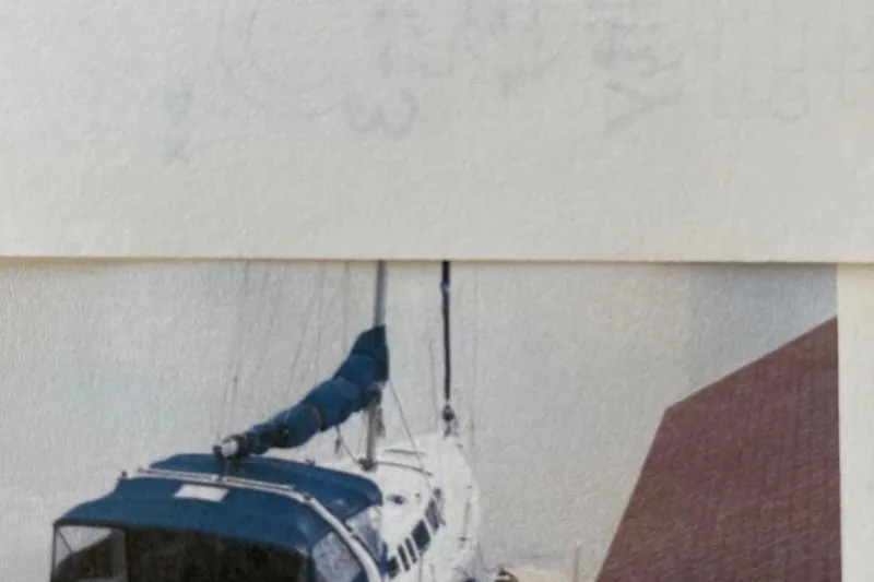 Slide: The Image of Sailboat with blue cover, Hunter 340 model, 1998, partially visible against a building. - 3