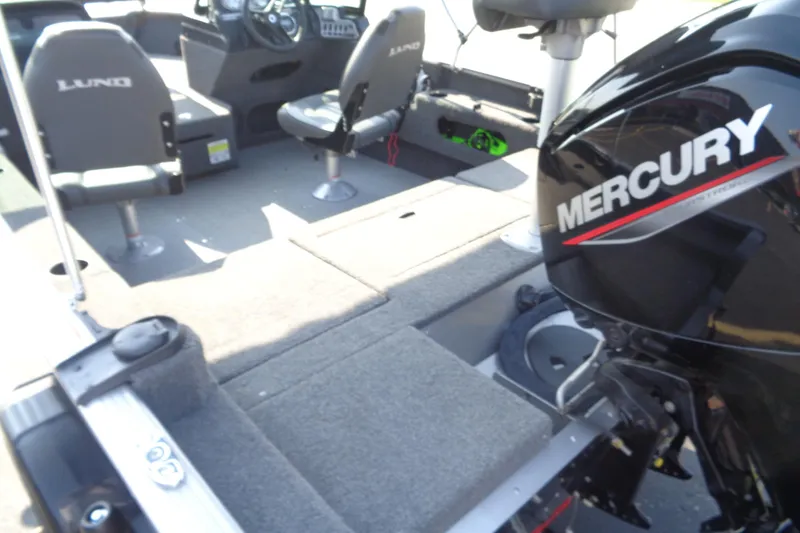 Slide: The Image of 2022 Lund 1675 Adventure Sport boat interior with Mercury engine, featuring seating and control console. - 12