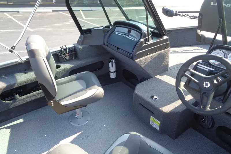 Slide: The Image of 2022 Lund 1675 Adventure Sport boat interior with steering wheel and seating. - 8