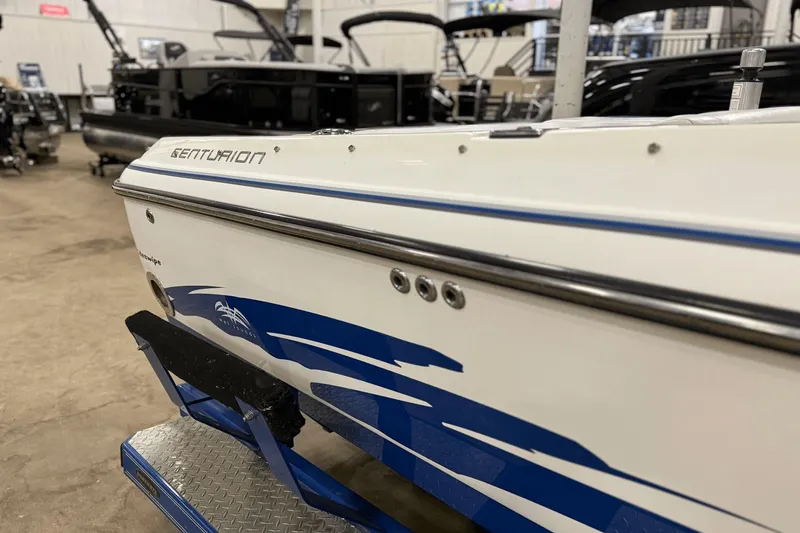 Slide: The Image of 2004 Centurion Avalanche C4 boat with blue and white design in a showroom. - 23