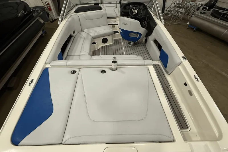 Slide: The Image of 2004 Centurion Avalanche C4 boat interior with white and blue seating, steering wheel, and spacious layout. - 6